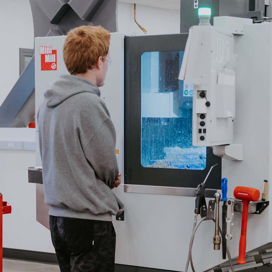 A student works with a machine in an engineering lab.