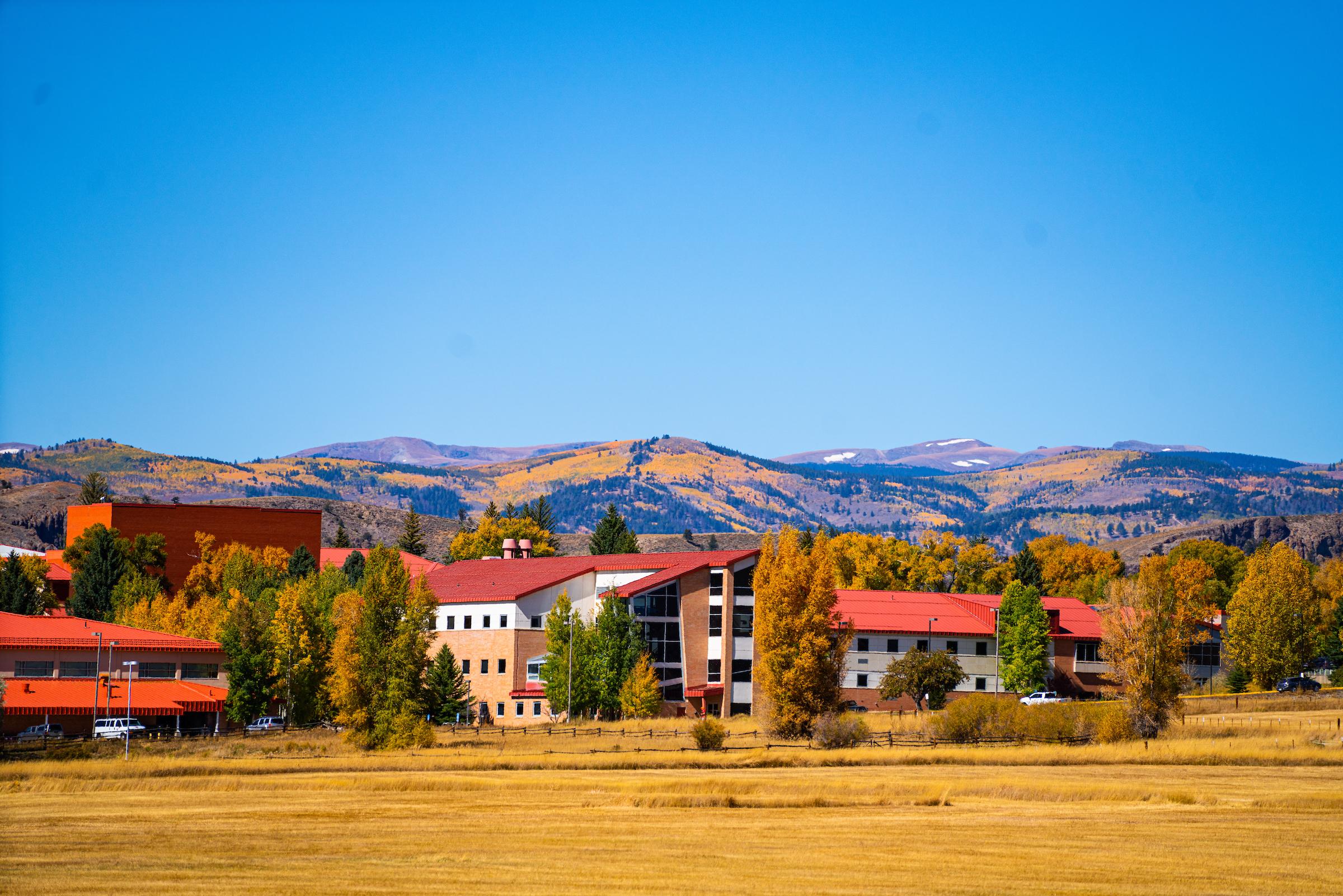 Hurst Hall viewed from large fields east of Western Colorado University's campus on a fall day.