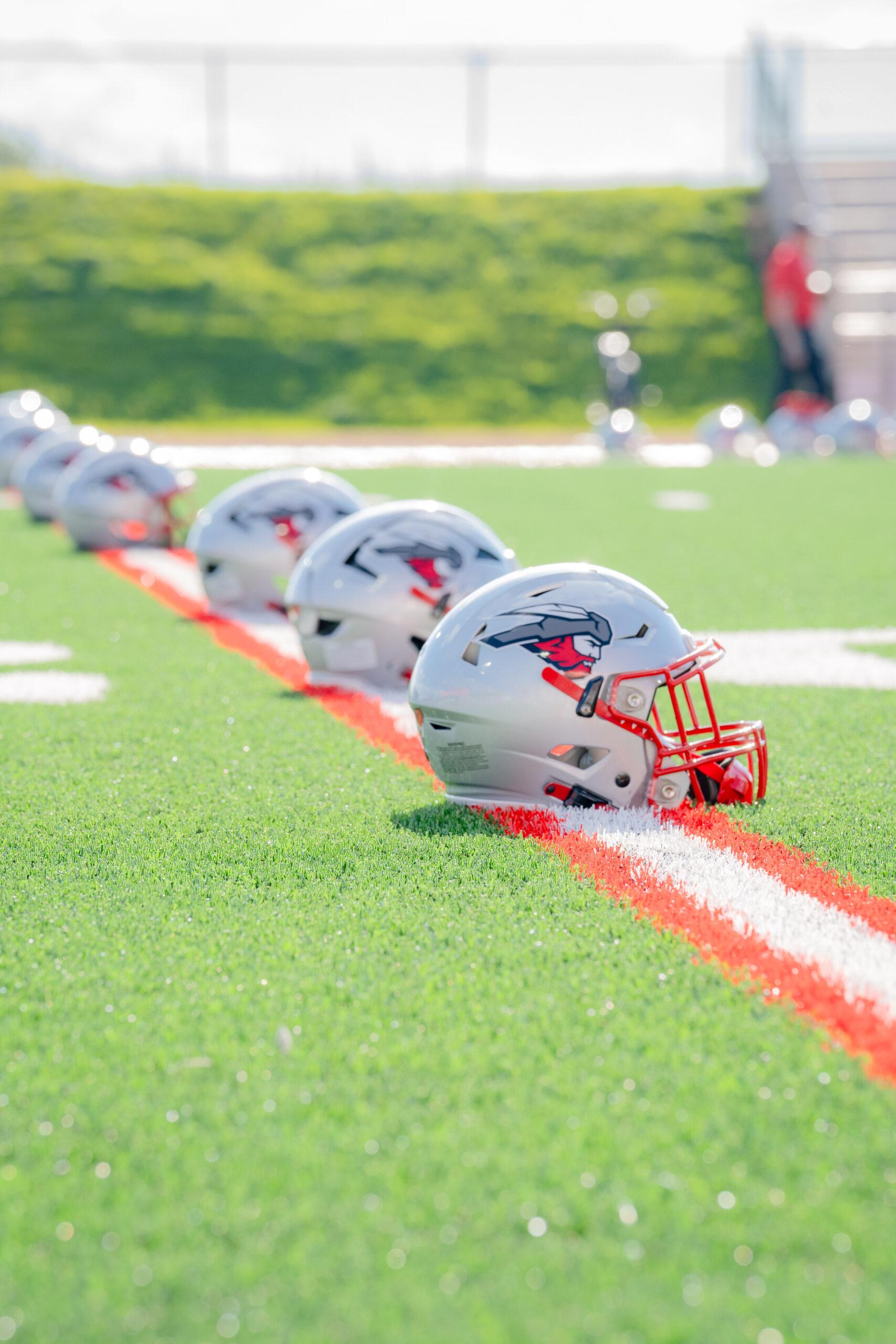 Western Colorado University football helmets on the 30 yard line.